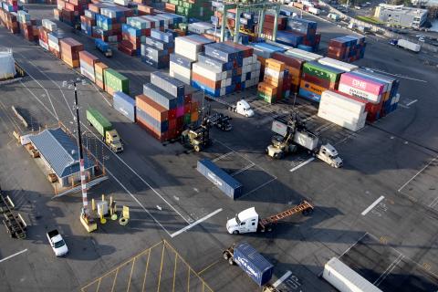 An aerial shot of a parking lot filled with trucks and containers. 